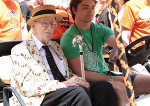 Donald Fletcher ’39 *51 riding in a gold cart during the 2024 P-rade