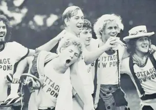 black and white photo of students clebrating and cheering during a blow pong tournament