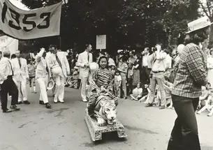RG_Family Affair.jpg Black and white photo of the 1977 P-rade featuring a little girl dressed in a tiger costume being pulled by a female marcher in front of the Class of 1953 marching