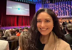 Allison Light ’18 take a selfie with the stage at the Los Angeles Times Book Prizes in the background.
