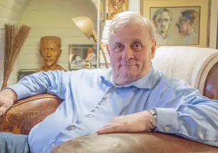 Edmund White sitting in a stuffed chair