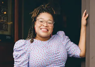 Morgan Keniks stands the doorway of Liz’s Book Bar in Brooklyn, New York