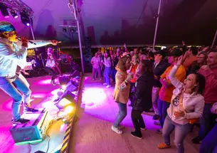 A band playing at the Class of 1995 tent during Reunions with people dancing