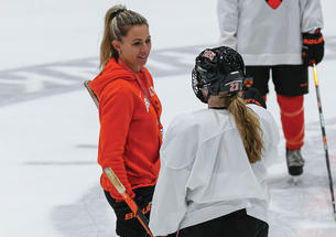 Cara Morey women’s ice hockey head coach talks to a plaey on the ice