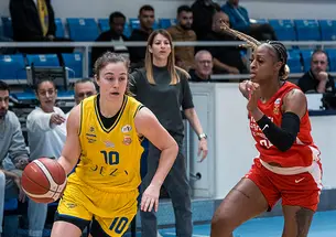 Abby Meyers dribbles a basketball past an opposing player.