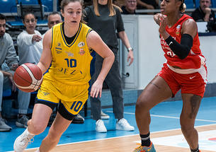 Abby Meyers dribbles a basketball past an opposing player.