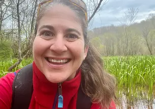 Karen Showalter in front of a river full of grasses.