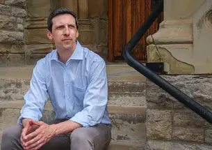 P.G. Sittenfeld ’07 sits on stone steps.