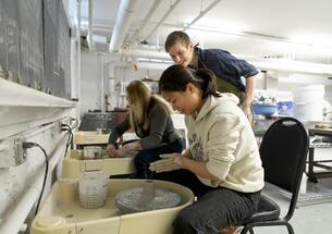 Students and instructor at pottery wheels