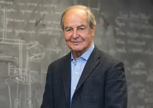 Frank P. Calaprice stands in front of a blackboard