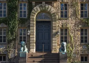 The ivy-covered front door of Nassau Hall, flanked by two bronze tiger statues.