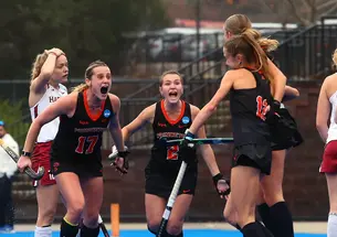 Field hockey players celebrate a goal