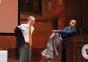 APGA President Laurence Latimer *01 surprises me onstage during the Many Minds, Many Stripes conference with a new APGA Reunions jacket. 