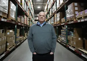 Rick Woldenberg ’81 stands in a warehouse.