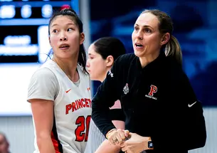 Carla Berube, right, with Kaitlyn Chen on the Princeton sideline at the Ivy Madness tournament in 2024.