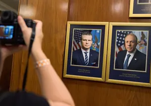 A photographer photographs department leadership portraits of Pete Hegseth ’03 and Steve Feinberg ’92 at the Pentagon in 2025.