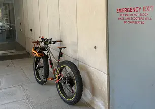 An e-bike leans against a campus building.