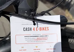 Cash 4 E-Bikes flyer on the handlebar of a parked e-bike 