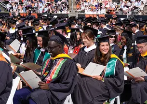 Princeton students in graduation regalia sit and wait for the commencement ceremony to start.
