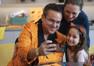 At left, Mario Moya ’01, his wife, Rebecca Hoberg, and their daughter, Anastasia, pause for a selfie before getting back to making art at the museum during Reunions.