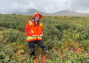 Hannah-Floyd_Alaska-Research.jpg Hannah Floyd ’27 stands in a field in Alaska wearing an orange and yellow vest and yellow hat.