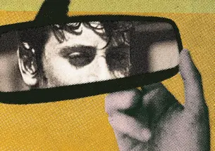 A green and yellow cover with an image of a review mirror where you can see half of a boys face and his hand on the mirror.