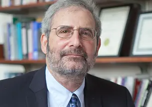 This is a headshot photo of Mark Beissinger, with a bookcase in the background.