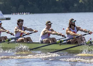 Four rowers from an eight man boat in action at a rowing regatta