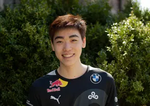 This is a headshot photo of Andrew Tang ’23 outside with shrubs in the background.