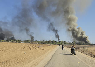 Palestinians walk away from a kibbutz, near the border fence with the Gaza Strip, while carrying out a deadly cross-border attack in southern Israel on Oct. 7, 2023.