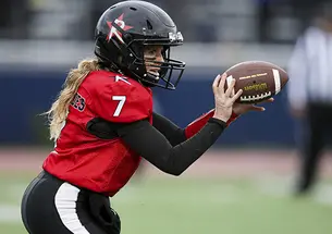 Boston Renegades quarterback Allison Cahill ’03 dishes the football to a running back in a game between the Boston Renegades and the Tampa Bay Inferno on June 3.