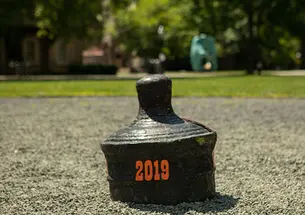 The back of a buried cannon is visible with "2019" written on it in orange.