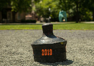 The back of a buried cannon is visible with "2019" written on it in orange.