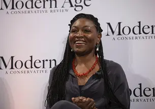 Christine Emba ’10 in front of a step-and-repeat that says "Modern Age: A Conservative Review."