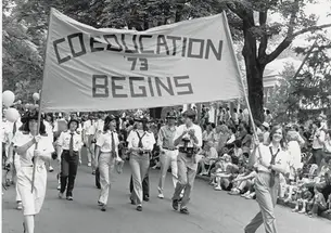 The Class of ’73 marches proudly with the “Coeducation Begins” banner at Reunions in 1983.
