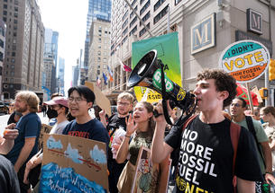 Princeton students on a street in New York City holding signs and bullhorn while marching