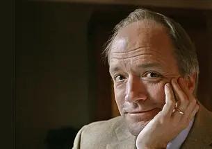 This is a headshot photo of Douglas McGrath ’80, his chin resting in his hand. 