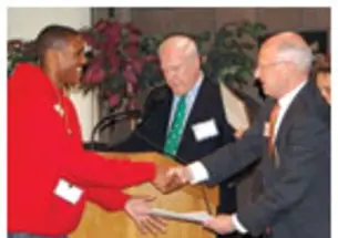 Henry Von Kohorn '66, second from right, assisted by Brian Breuel '66 and Marguerite Vera '79, recognize Princeton Prize winner Sidney Johnson during a race-relations symposium on campus.