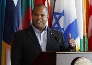 Dallas Mayor Eric Johnson *03 speaks at a podium.