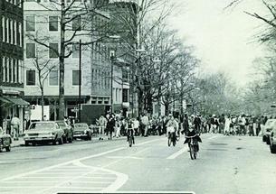 A black-and-white photo on the cover of PAW showing people bicycling down Nassau Street and a sign reading "Road Closed."