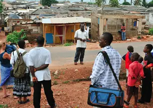 Professor Carolyn Rouse (second from left) documents elder Jacob Otabil’s tour of Oshiyie, Ghana, site of the school she is building. She notes that “what looks like poverty and suffering to some is challenged by Otabil’s description of a vibrant co