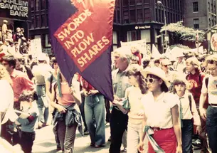 Dorman carries the banner in a 1982 march for a nuclear freeze. His three daughters are pictured beside him.