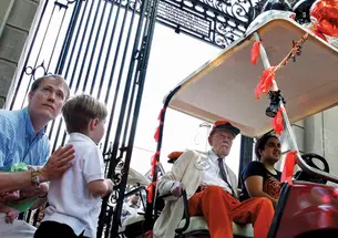 Riding in his golf cart at the P-rade in 2011, Warnock passes PAW writer W. Barksdale Maynard ’88 and his son, Alexander. 