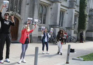 Howard Levy ’85, left, holds up photos of Israeli hostages at the pro-Palestinian student encampment in McCosh Courtyard on April 25.