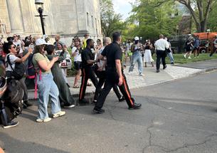 Two protesters are arrested by Public Safety officers and loaded onto a bus during the occupation of Clio Hall on April 29.