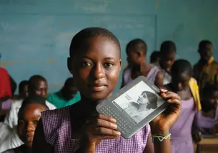 A girl in Ghana holds an e-reader provided by Worldreader.org.