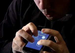 Ge Wang *08, below, created Ocarina, which can turn the iPhone into a flutelike instrument. Above, he demonstrates how it is played.