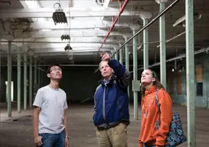 Visiting lecturer Robert Harris, center, and seniors Eric Hui and Emily Weissinger discuss the renovation of a vacant factory.