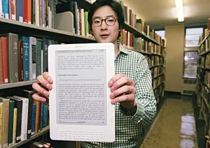 Brian No ’10 with the Kindle DX e-reader, which is being used by three Princeton classes in a pilot program this fall.