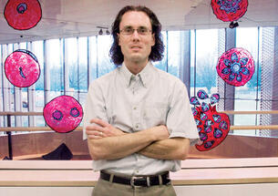 Assistant professor Manuel Limas hopes to find ways to break the malaria parasite's 48-hour cycle, depicted in the illustrations at Icahn Lab.